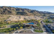 Stunning aerial view of the property with pool, mountain views and nearby new construction lots at 9807 S 11Th St, Phoenix, AZ 85042