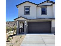 Charming two-story home featuring neutral paint, a dark gray garage door and desert landscaping at 9807 S 11Th St, Phoenix, AZ 85042