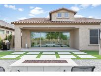 Backyard featuring artificial grass, a fire pit, patio area, and sliding glass doors to the home's interior at 1816 N Bernard Cir, Mesa, AZ 85207