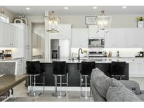 Open-concept kitchen with stainless steel appliances, granite island with chairs and modern pendant lighting at 1816 N Bernard Cir, Mesa, AZ 85207