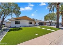 Charming single-story home featuring a well-manicured lawn and a modern exterior design at 8215 E Virginia Ave, Scottsdale, AZ 85257