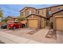 View of townhome with paved driveway and garage and gate to front courtyard at 250 W Queen Creek Rd # 206, Chandler, AZ 85248