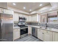 Modern kitchen featuring stainless steel appliances, light cabinets, and stone countertops at 2502 E Malibu Dr, Tempe, AZ 85282