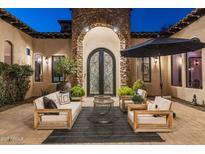 Inviting courtyard with cozy seating area and statement stone turret entrance with wrought iron doors at 2782 E Citadel Ct, Gilbert, AZ 85298