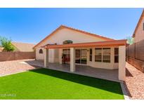 An airy back patio, complete with artificial grass and a tiled seating area, is great for entertaining at 2904 E Ludlow Dr, Phoenix, AZ 85032