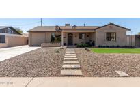 Charming home featuring a desert landscaped yard with a stone pathway leading to the front door at 3301 E Sharon Dr, Phoenix, AZ 85032
