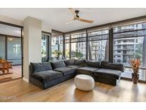 Inviting living room features a large sectional sofa, wooden floors, and floor-to-ceiling windows at 4808 N 24Th St # 303, Phoenix, AZ 85016