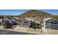 Aerial view of a two-story home with desert landscape and a three-car driveway at 1758 N 74Th Pl, Mesa, AZ 85207