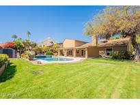 Spacious backyard with green lawn, pool, and covered patio at 2317 E Desert Cove Ave, Phoenix, AZ 85028