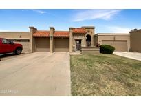 Charming single-story home with a well-maintained lawn and multiple car garage at 10014 E Michigan Ave, Sun Lakes, AZ 85248