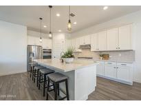 Beautiful kitchen with pendant lighting, stainless steel appliances, and a large center island at 10134 E Supernova Dr, Mesa, AZ 85212