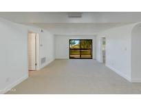 Spacious living room with bright white walls and plush carpeting, featuring a sliding glass door at 10444 N 69Th St # 224, Paradise Valley, AZ 85253
