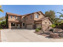 Stunning two-story home with a spacious driveway and a well-maintained front yard featuring stone accents at 13514 W Banff Ln, Surprise, AZ 85379