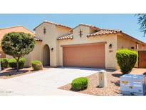 Charming single-story home featuring a desert landscape, tile roof, and a spacious two-car garage, offering a great curb appeal at 1437 E Flamingo Way, Gilbert, AZ 85297