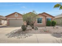 Charming single-story home featuring a low-maintenance desert landscaped front yard and attached two car garage at 18051 W Port Royale Ln, Surprise, AZ 85388