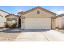 Beige one story home featuring a two car garage and low maintenance desert landscaping at 3323 W Fraktur Rd, Phoenix, AZ 85041