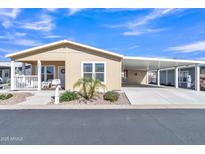 Charming tan home with a covered porch, low maintenance landscaping, and covered parking perfect for Arizona living at 40511 N Birdie St, San Tan Valley, AZ 85140