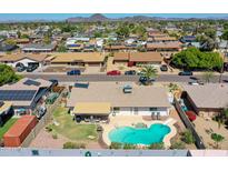 Aerial view of a backyard with a pool, patio, and well-maintained landscaping in a residential neighborhood at 4139 W Anderson Dr, Glendale, AZ 85308