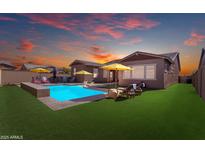 Backyard pool with lounge seating and umbrellas against a colorful sunset sky at 4247 S Zenith --, Mesa, AZ 85212