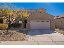 Charming two-story home showcasing a neutral color scheme, two-car garage, and desert landscaping at 5139 W Shumway Farm Rd, Laveen, AZ 85339