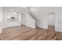 Bright living room featuring wood floors, stairs to second floor and open kitchen with white cabinets at 520 N Stapley Dr # 123, Mesa, AZ 85203