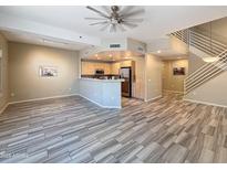 Open-concept living room with wood-style floors, modern lighting, and adjacent kitchen at 16 W Encanto Blvd # 2, Phoenix, AZ 85003