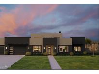 Striking contemporary home boasts clean lines, neutral tones, and lush landscaping against a colorful dusk sky at 5439 E Bloomfield Rd, Scottsdale, AZ 85254