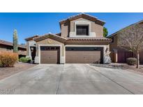 Two-story home with a two-car garage, desert landscaping, and a neutral color palette, set against a bright blue sky at 8246 W Melinda Ln, Peoria, AZ 85382