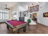 Spacious game room features a pool table, high ceilings, and staircase with stone accent wall at 8246 W Melinda Ln, Peoria, AZ 85382