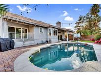 Backyard view of sparkling pool, beautiful landscaping, and charming outdoor living area at 502 W Sierra Madre Ave, Gilbert, AZ 85233