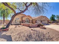 Charming single-story home with decorative rock landscaping, appealing architectural details, and a three-car garage at 1289 E Palo Blanco Way, Gilbert, AZ 85296