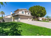 Charming home featuring a large three-car garage, verdant lawn, and established shade trees at 1920 E Belmont Dr, Tempe, AZ 85284
