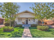 Charming bungalow with well-maintained lawn, mature trees, and inviting front porch at 2034 N Dayton St, Phoenix, AZ 85006