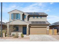 Two-story home featuring a tile roof, two-car garage, solar panels, and desert landscaping for low maintenance at 21572 W Sonora St, Buckeye, AZ 85326