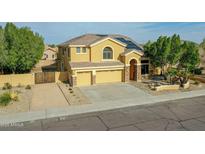 Two-story home featuring a three-car garage, desert landscaping, and solar panels on the roof at 25453 N 68Th Ln, Peoria, AZ 85383