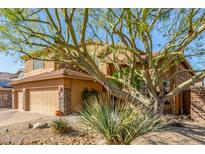 Inviting two-story home featuring a desert landscape and a three-car garage with stone accents at 3206 W Sentinel Rock Rd, Phoenix, AZ 85086