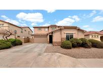 Charming home featuring a well-manicured lawn, a two-car garage and a driveway in a residential area at 6818 W St Catherine Ave, Laveen, AZ 85339