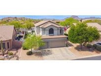 Charming two-story home featuring a tile roof and a well-manicured front yard with mature trees at 7242 E Tyndall St, Mesa, AZ 85207