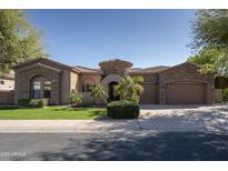 Charming stone-accented home featuring a well-manicured lawn, beautiful entry, and a two-car garage at 8925 E Ann Way, Scottsdale, AZ 85260