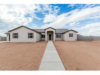 Inviting single-story home with neutral stucco, brown shutters, and a concrete walkway on an ample lot at 9430 W Sandstone Mountain Dr, Casa Grande, AZ 85194
