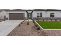 Charming single-story home featuring a low maintenance, desert-friendly front yard and a modern garage door at 10981 W Woodruff Rd, Casa Grande, AZ 85194