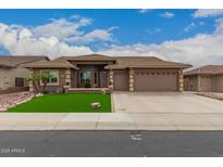 Charming home featuring manicured landscaping, a three-car garage, and a welcoming entryway at 11055 E Ocaso Ave, Mesa, AZ 85212
