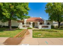 Charming single-story home featuring a red tile roof, lush landscaping, and mature shade trees in a well-maintained front yard at 1934 E Hale St, Mesa, AZ 85203