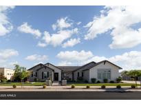 Charming single-story home with a brick facade, manicured lawn, and a welcoming entrance at 19901 E Country Meadows Dr, Queen Creek, AZ 85142