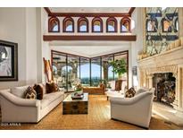 Bright living room with high ceilings, fireplace, large picture window, and sophisticated decor at 26796 N 98Th Way, Scottsdale, AZ 85262