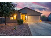 Charming single-story home featuring a two-car garage and low-maintenance desert landscaping at dusk at 30370 N Opal Dr, San Tan Valley, AZ 85143