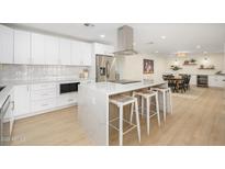 Spacious kitchen with white cabinets, stainless steel appliances, and an island with seating at 7346 E Mckinley St, Scottsdale, AZ 85257