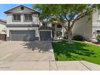 Charming two-story home features a two-car garage and well-maintained front yard with mature tree providing shade at 9618 E Monterey Ave, Mesa, AZ 85209