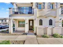 Charming two-story home featuring a balcony, arched windows, and a well-maintained front yard with a white picket fence at 9906 E Wavelength Ave, Mesa, AZ 85212