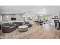 Open concept living room with light hardwood floors, ample seating, and lots of natural light at 12411 N 57Th St, Scottsdale, AZ 85254